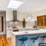 gloss white and stainless steel corner kitchen