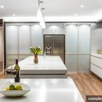 Staron by Samsung surfaces. Project includes gloss white cabinetry, stainless steel appliances and open plan between inside and outside and polished timber floorboards.