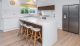 Modern white gloss kitchen design with timber finishings and stainless steel appliances