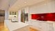 kitchen design ideas with a red splashback, gloss white cabinetry, stainless steel appliances and timber flooring