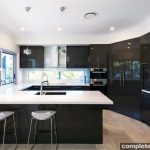 Built to accommodate the needs of avid entertainers, this dark kitchen is practical and makes the most of the surrounding views.