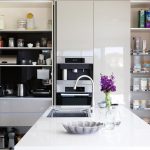 A white modern kitchen with a tap and flowers