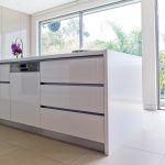 A white sleek kitchen with big windows