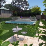 A modern pool newt to a lawn and outdoor furniture