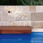 Modern pool closeup with a wooden bench