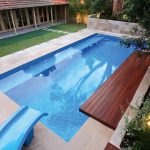 A modern pool view from above with a bench and a water slide