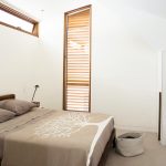 A simple bedroom is layered with lush materials and furnishings