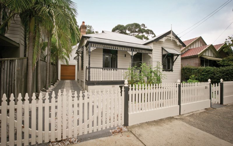 The traditional exterior of the home is juxtaposed by the stone driveway
