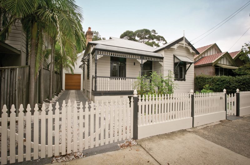 The traditional exterior of the home is juxtaposed by the stone driveway