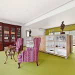 The generous bedroom is divided by cabinets