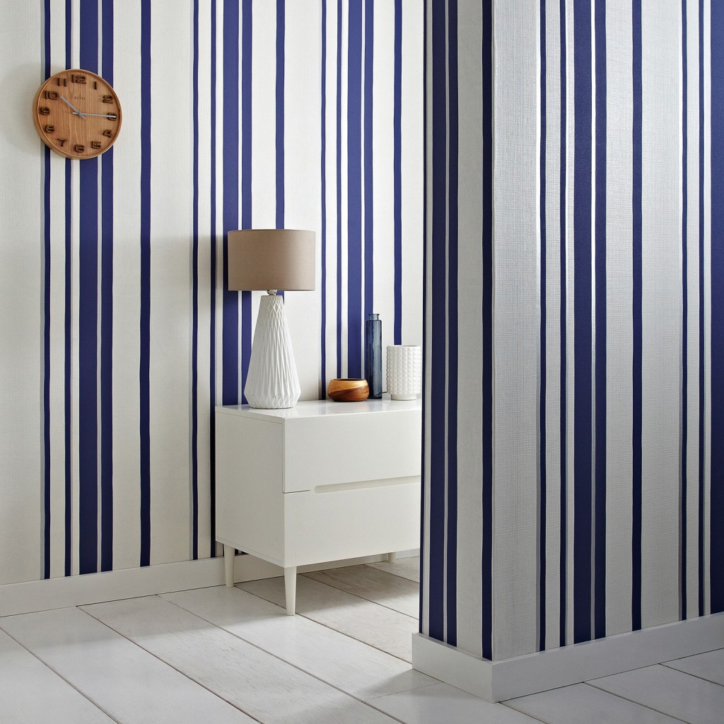 Expand a small space or create the illusion of high ceilings with the Hoppen Stripe wallpaper in white and Prussian blue from GRAHAM & BROWN. The white stripes are textured with a linen effect while a subtle silver strip lines either side, making it pop. grahambrown.com/uk