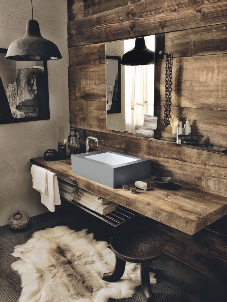 Smoothly set into Corian in the industrial grey Deep Cloud shade, the Corian Refresh washbasin offers a touch of contemporary chic to the wooden vanity top’s rough texture, providing an unexpected twist to a rustic ambience.
