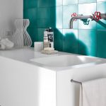 Bathed in Mediterranean sunlight, artisan-style aquamarine tiles contrast with the velvety smooth touch of a Corian Serenity basin set into a Corian Glacier White vanity top. The space evokes the fresh fragrance of a bright summer morning by the sea.