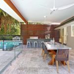 The outdoor kitchen incorporates a bar-style eating area complemented by stool seating