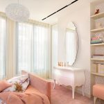 A feminine room is created using soft pinks and patterned wallpaper