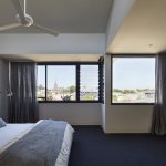 Natural light floods the bedroom, which is ideal when using a darker interior scheme