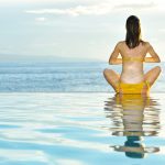 Woman doing yoga at poolside