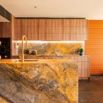 Wide shot of a luxurious kitchen filled with orange, yellow and gold hues