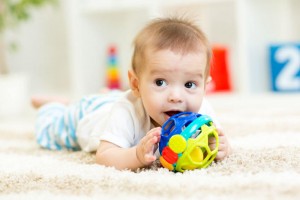cute baby lying on soft carpet in children room