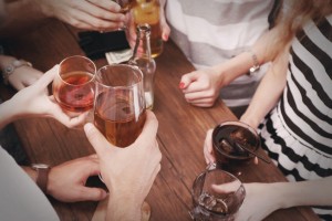 top view of hands holding alcoholic drinks at a bar