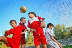 adolescent boys playing soccer near a goal