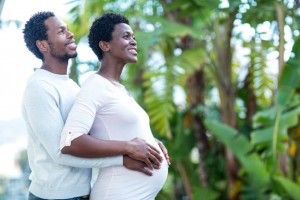 Happy man embracing wife while standing in park