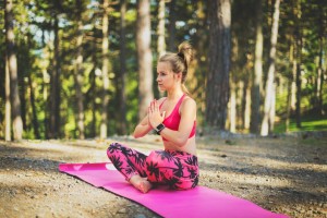 young woman practicing mindfulness meditation in the woods