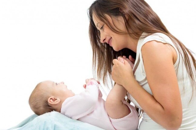 baby looking at mother while on her lap