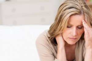 woman suffering from pain holiding her neck with one hand and the other on her head