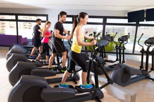 Aerobics elliptical walker trainer group at fitness gym workout