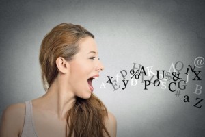Side view portrait woman talking with alphabet letters coming out of her open mouth