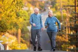 elderly couple walking for exercise with weights