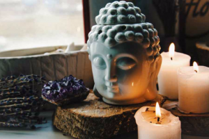 spiritual ritual meditating face of Buddha ametist candles on old wooden background Esoteric tonal curves color