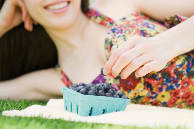 Young woman eating blueberries