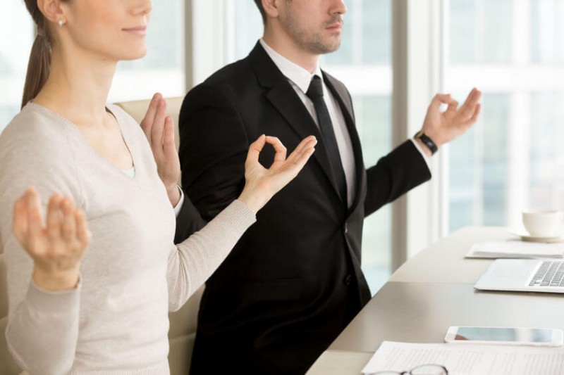 business people meditating at desk