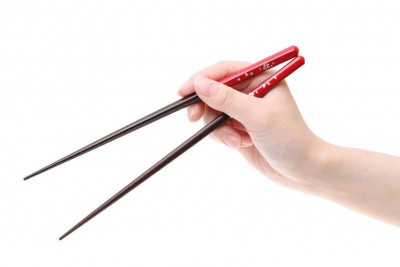 Hand holding wooden chopsticks