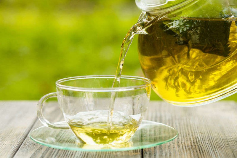 Herbal green tea in a glass teapot on the table outdoor