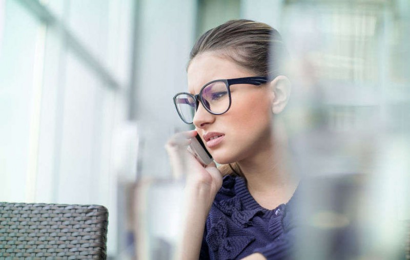 Frowning young woman talking on phone