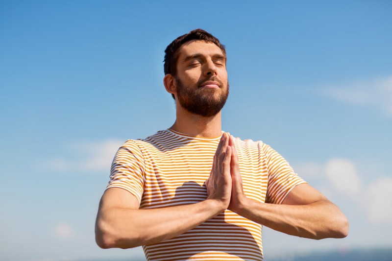 young man meditating outdoors