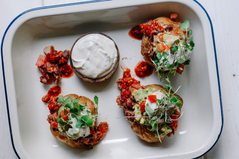 Jacket Potatoes with refried beans, guacamole & cashew sour cream - WellBeing Magazine