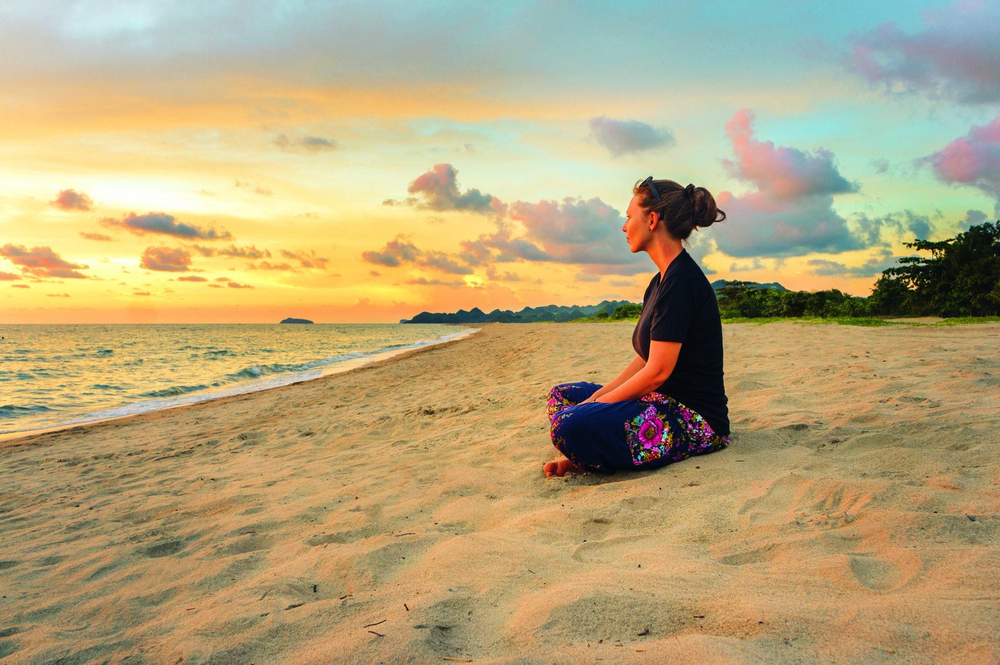 Woman Relaxing On Beach At Sunset